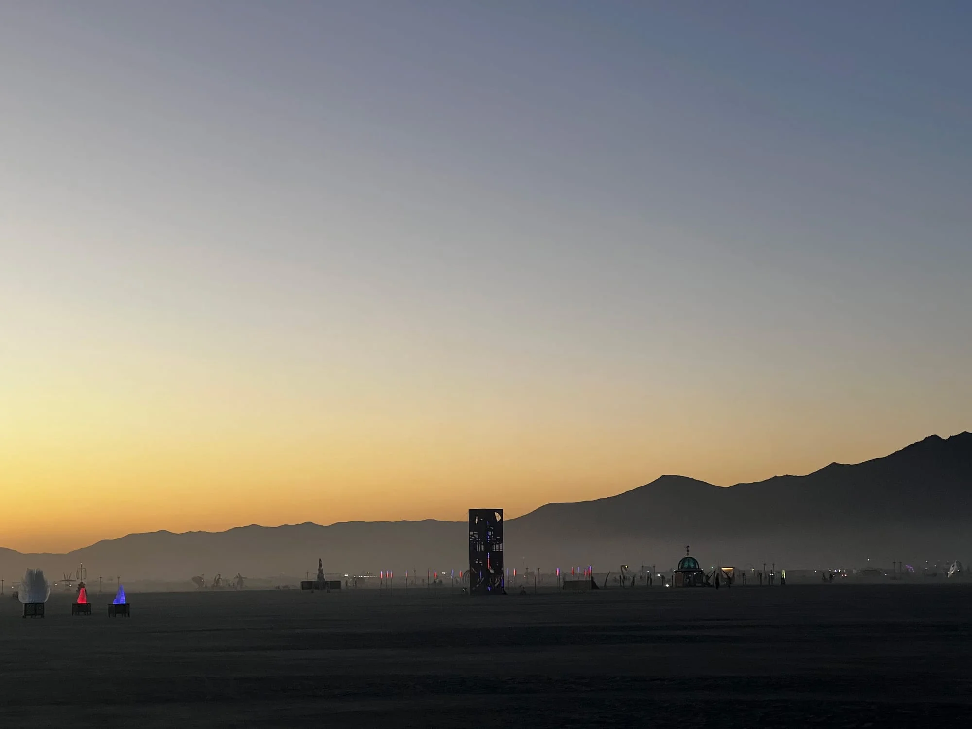 THEM sculpture at Burning Man casting dramatic shadows on desert floor